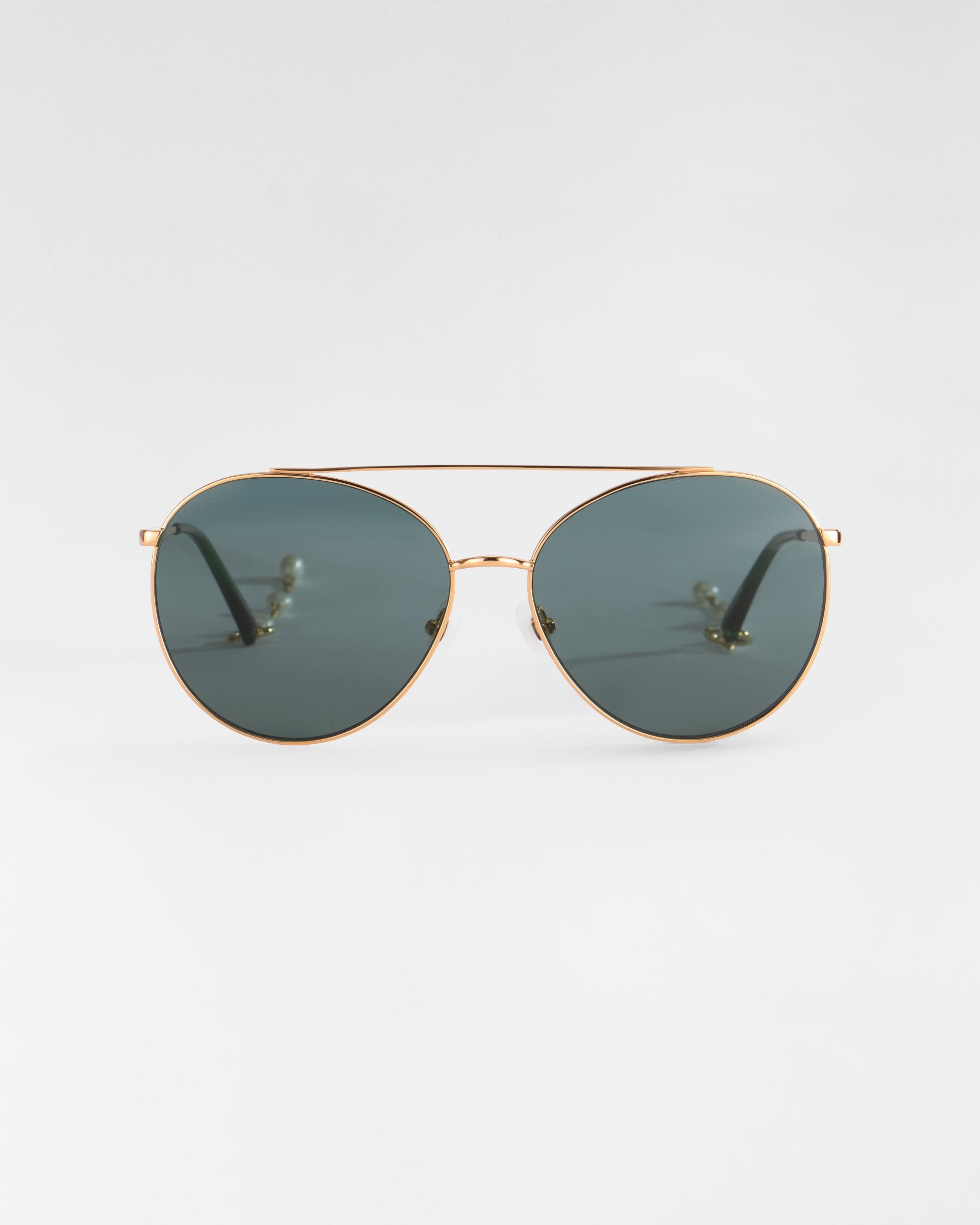 A pair of Yoyo sunglasses by For Art&#39;s Sake® with thin, 18k gold-plated frames and dark green lenses is displayed against a plain white background.