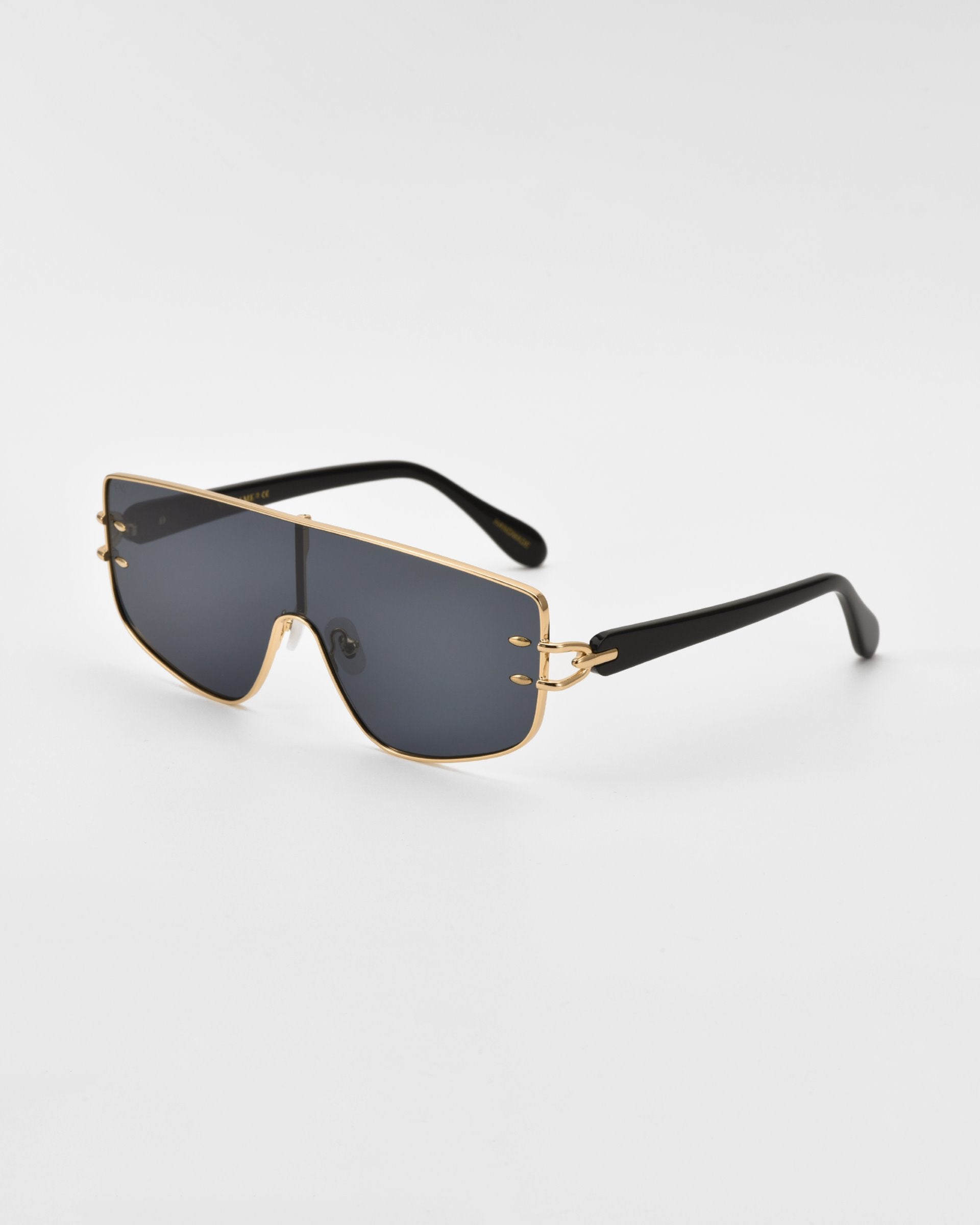 For Art&#39;s Sake® Flare sunglasses with a black frame and gold accents, featuring large, dark lenses offer a touch of luxury eyewear. The arms are black with a noticeable gold hinge detail near the lenses, all set against a plain white background.