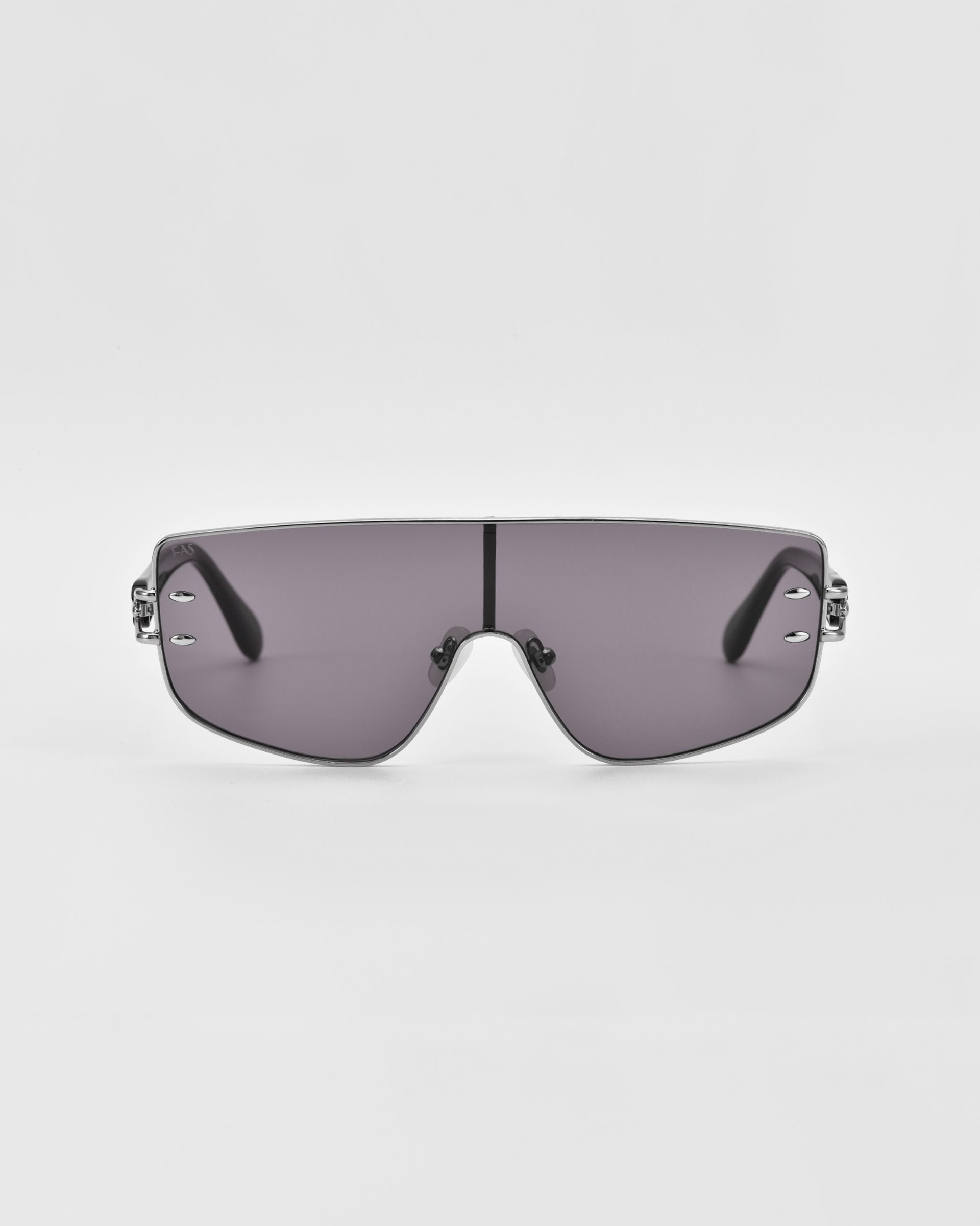 Introducing the Flare sunglasses by For Art&#39;s Sake®—a pair of futuristic-style luxury eyewear featuring a single, continuous gray-tinted lens and thin, black arms. The minimalistic nose bridge complements the sleek, slightly curved design of the lens. Set against a plain white background, these are the epitome of modern elegance.