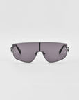 Introducing the Flare sunglasses by For Art's Sake®—a pair of futuristic-style luxury eyewear featuring a single, continuous gray-tinted lens and thin, black arms. The minimalistic nose bridge complements the sleek, slightly curved design of the lens. Set against a plain white background, these are the epitome of modern elegance.