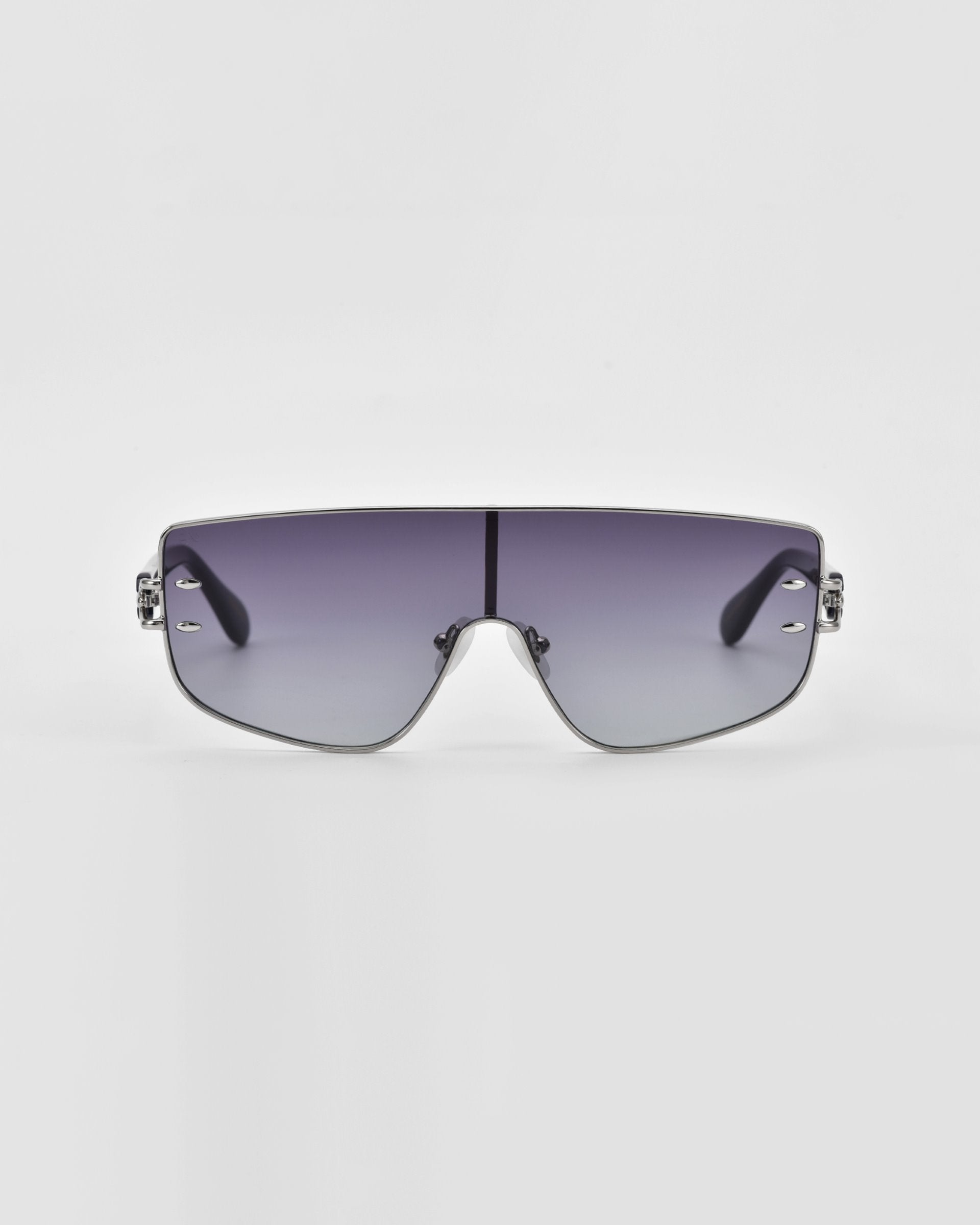 A pair of stylish, oversized For Art&#39;s Sake® Flare sunglasses with a silver frame and gradient lenses. The lenses transition from dark at the top to lighter at the bottom, and the frame has minimalistic, sleek detailing. This luxury eyewear piece stands out against a plain white background with its futuristic design.