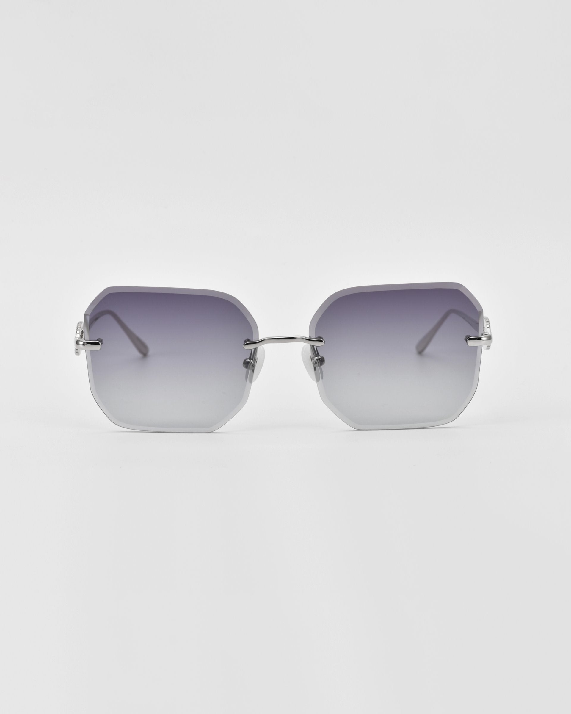 A pair of For Art&#39;s Sake® Aria rimless sunglasses with gradient lenses transitioning from dark gray at the top to light gray at the bottom. The sunglasses have thin, silver-tone metal arms and lack any visible jade-stone nose pads or additional frame components. The background is white.