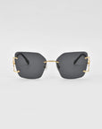 A pair of modern, oversized square lenses sunglasses with dark tinted lenses and gold-colored metal accents on the temples. The For Art's Sake® Starlit sunglasses feature jade-stone nosepads, and the minimalistic frame lacks a visible border around the lenses, creating a sleek and stylish design against a plain white background.