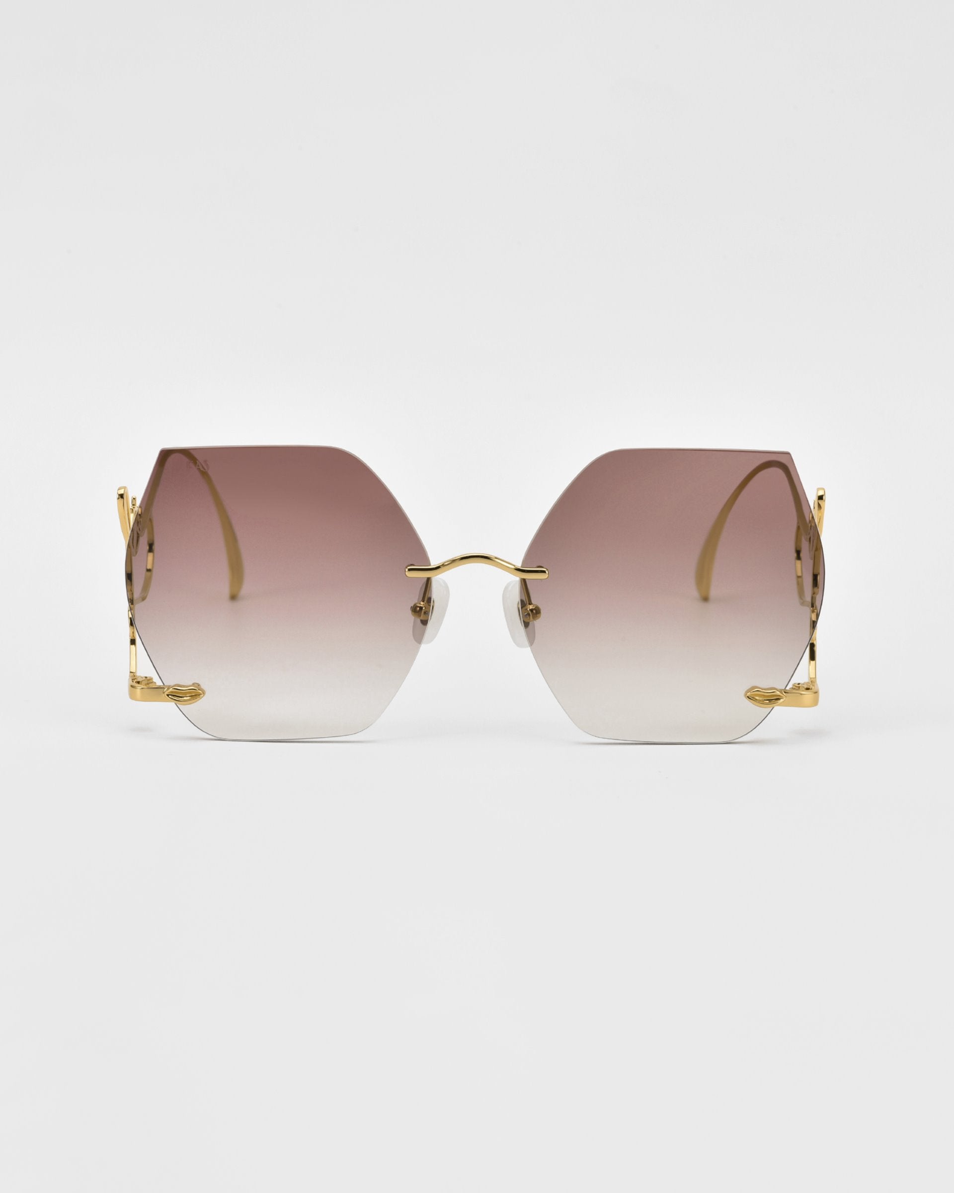 A pair of limited edition Cry Me a River hexagonal sunglasses with gradient lenses transitioning from dark brown at the top to clear at the bottom. The sunglasses feature gold-toned metal temples and a minimalist frame design, set against a plain white background. The brand is For Art&#39;s Sake®.