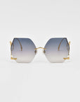 A pair of For Art's Sake® Cry Me a River hexagonal gradient sunglasses with gold frames is displayed against a plain white background. The lenses transition from dark at the top to nearly clear at the bottom, and the thin arms feature intricate detailing near the hinges.