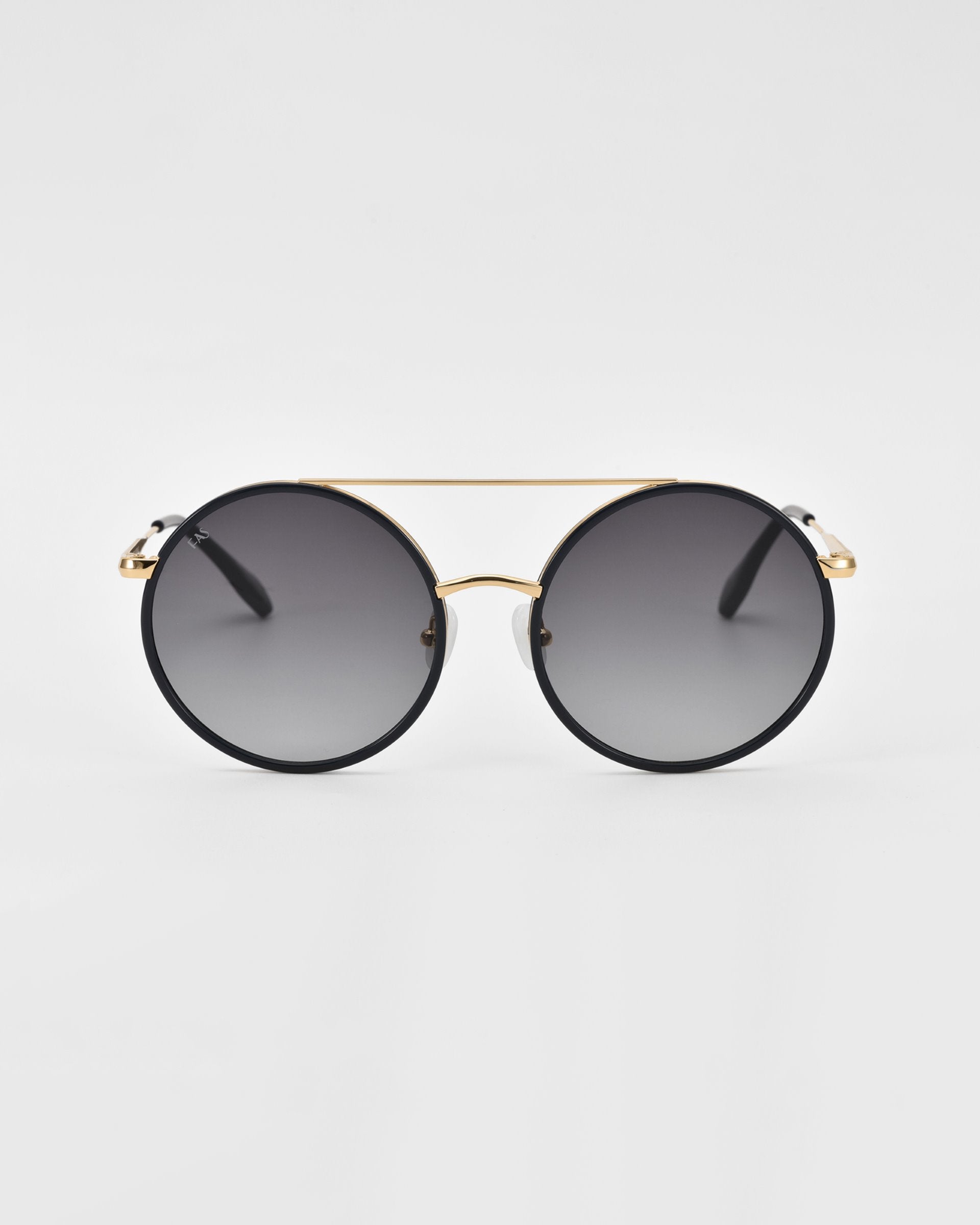 A pair of For Art's Sake® Orb oversized round aviator sunglasses with dark gradient lenses and a thin gold frame. The design features a distinct double bridge and black arms with gold accents at the hinges, complemented by jade-stone nose pads. The background is plain white, highlighting the stylish and modern design.