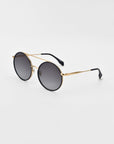 A pair of oversized round aviator sunglasses with black lenses and thin gold-colored frames. The temples feature black ear pieces, and the jade-stone nose pads enhance comfort. The plain white background accentuates the sleek design of these chic Orb sunglasses by For Art's Sake®.