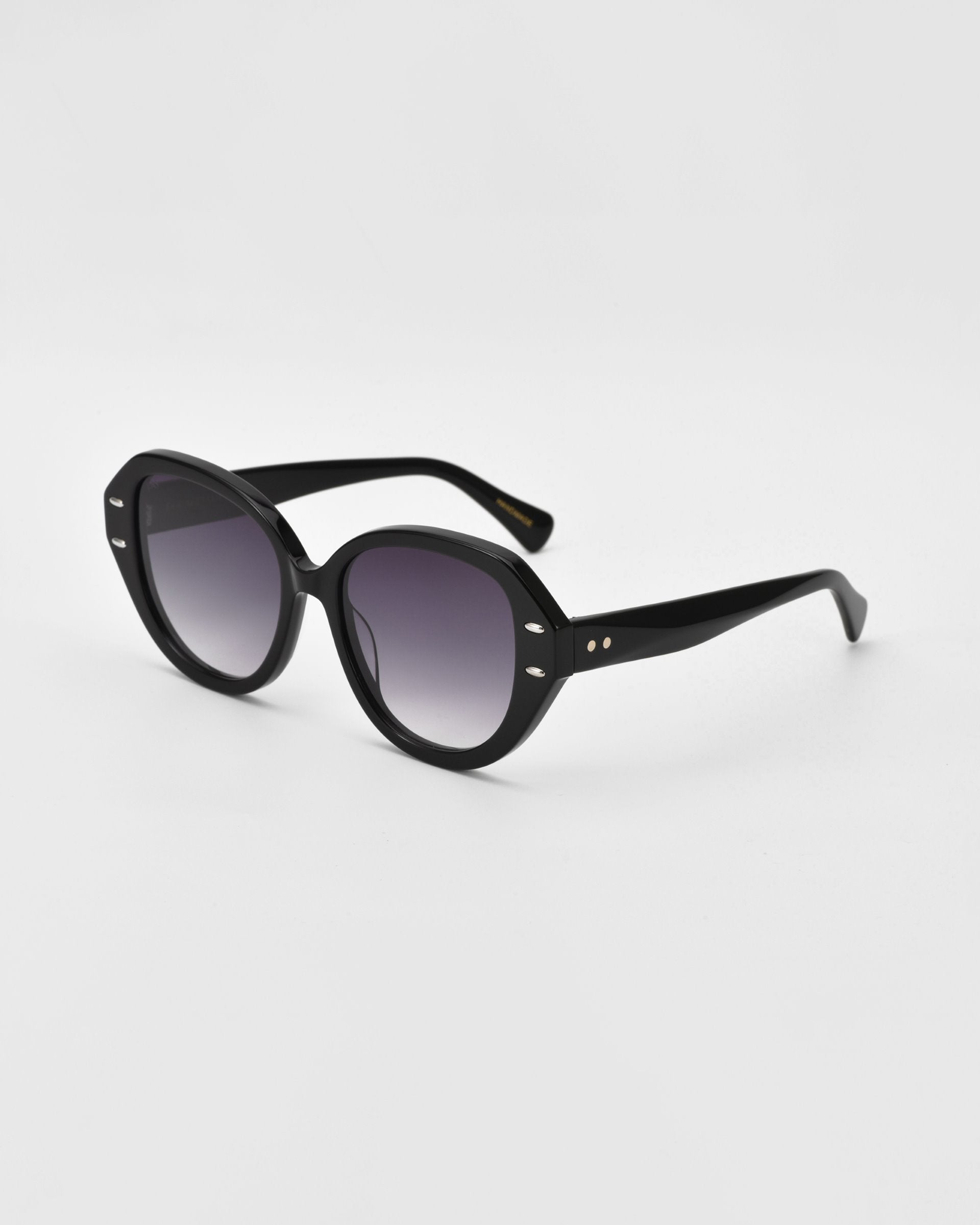 A pair of black round sunglasses with dark tinted lenses. The frame, crafted from plant-based acetate, has a glossy finish with small metallic accents near the hinges on the arms. The background is plain white.

Mirage by For Art's Sake®