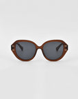 A pair of oversized, round, brown-framed Mirage sunglasses by For Art's Sake® with dark-tinted lenses. The frame, made from plant-based acetate, features a glossy finish. The Mirage sunglasses are set against a plain white background.