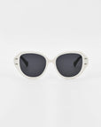 A pair of white-framed Mirage sunglasses by For Art's Sake® with black lenses, set against a plain white background. The design features rounded edges and a slightly retro style, crafted from plant-based acetate.