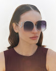 A model wearing the Sapphire sunglasses in Black.  Showing off the large gradient frames with silver lining. 